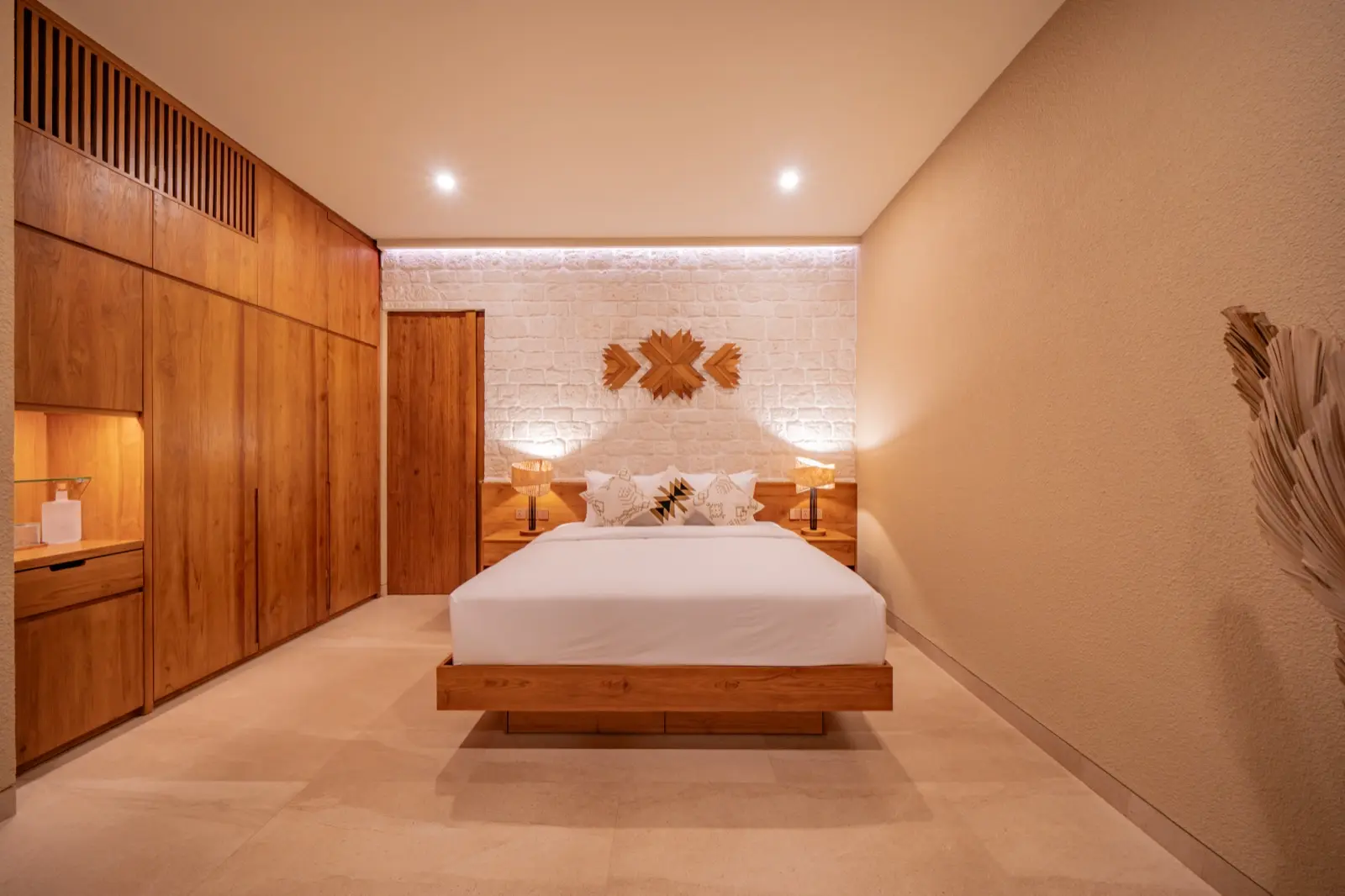 Timber wardrobe wall and carved headboard in bedroom two at Villa Navaho