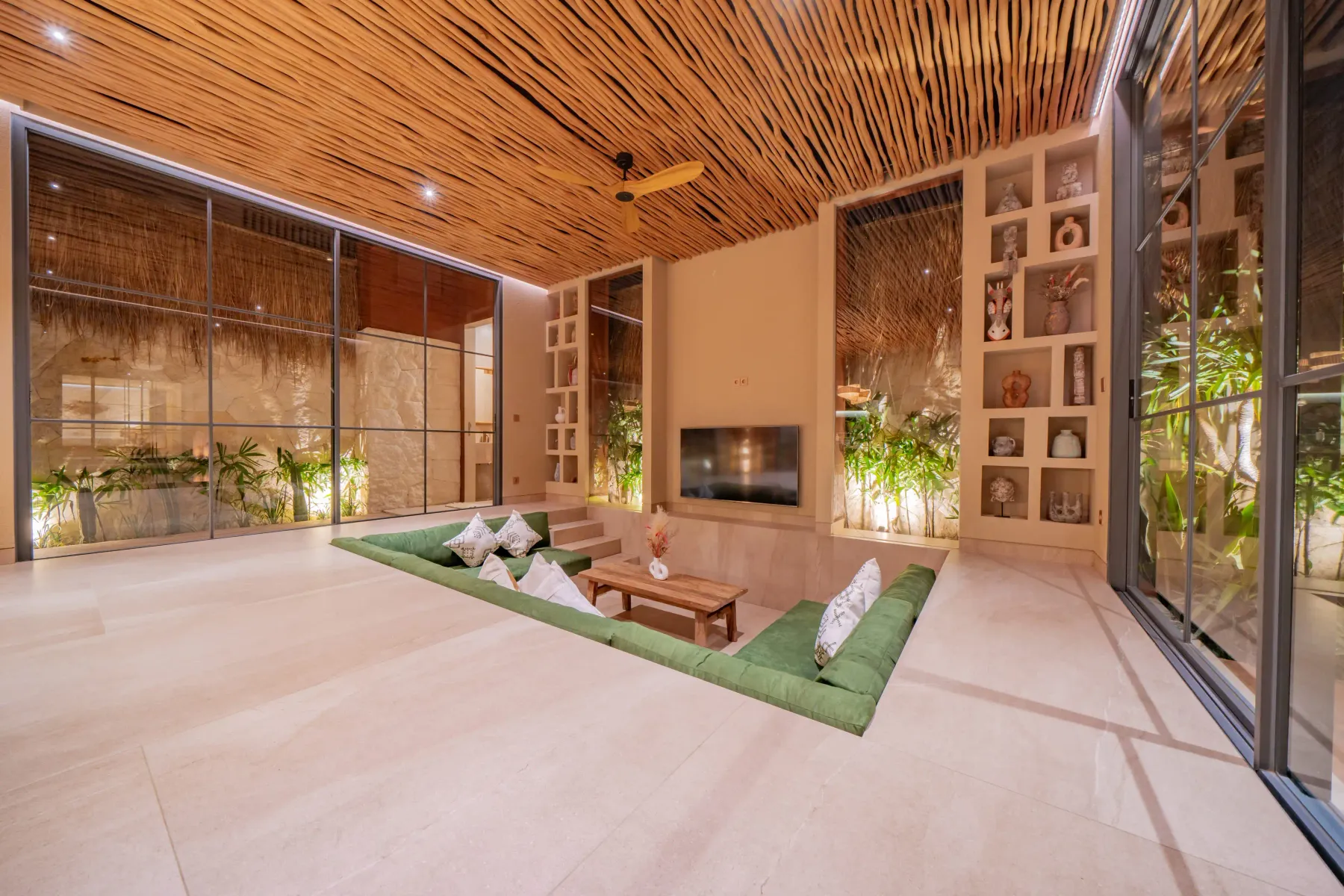 Sunken green lounge open to the garden in the living room at Villa Navaho, Bumbak Bali