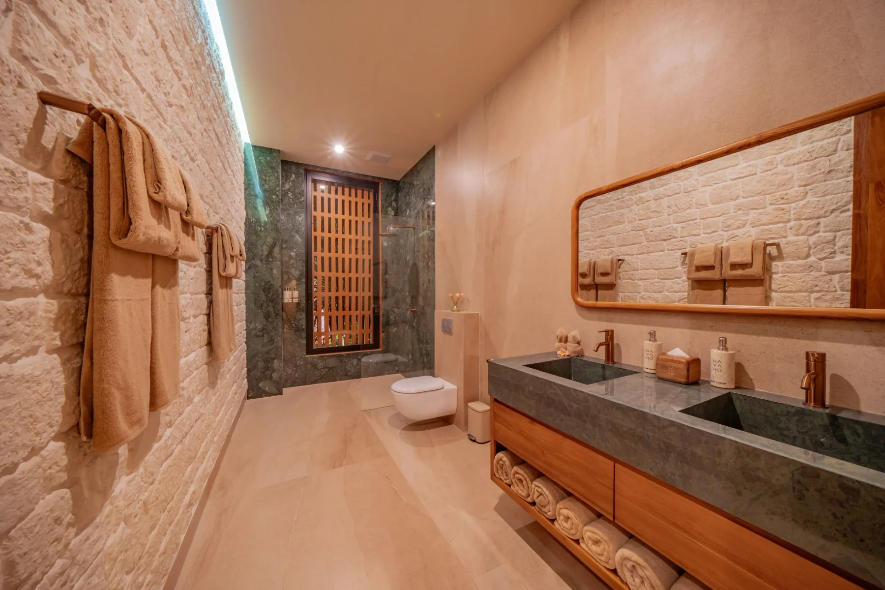Ensuite bathroom with a long stone vanity and timber mirror at Villa Navaho