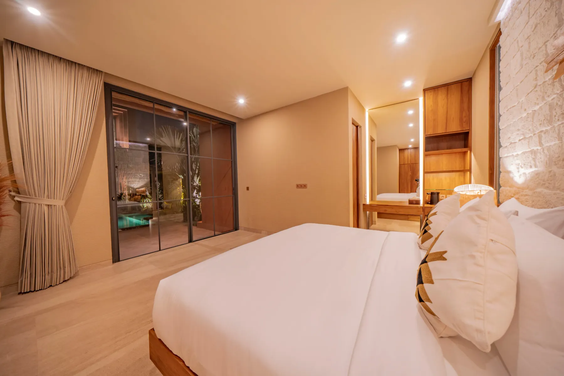Master bedroom with glass doors onto the pool deck at Villa Navaho, Bumbak Bali