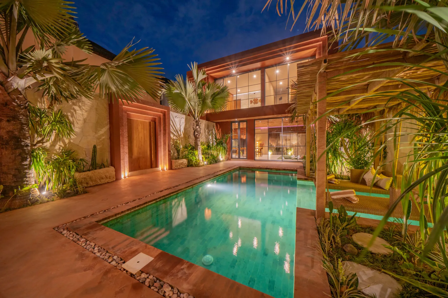 The villa lit up behind the pool at dusk, Villa Navaho, Bumbak Bali
